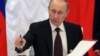 Russia -- President Vladimir Putin signs a law on ratification of a treaty making Crimea part of Russia, during a ceremony in the Kremlin in Moscow, March 21, 2014