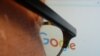 A journalist looks at the new Google logo at his work station in Washington