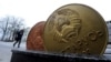 Belarus - A man walks past the giant Belarusian ruble coin monument near the Ministry of taxes-and-duties in Minsk. 22Feb2017